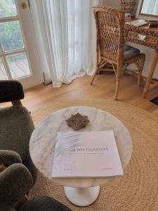 a living room with a table with a sign on it at Moana bungalow in Hideaway Bay +13 photos