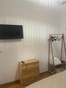 a room with a tv on a wall with a wooden cabinet at Piazzetta Degli Innamorati in Bari
