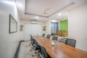 a conference room with a long wooden table and chairs at HOTEL KB's Grand in Shirdi