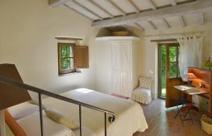 a bedroom with a bed and a desk and a piano at Casa Dell'Ambasciatore in Vivo dʼOrcia