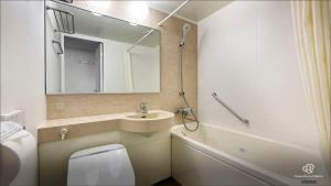 a bathroom with a sink and a toilet and a mirror at Daiwa Roynet Hotel Mito in Mito +17 photos