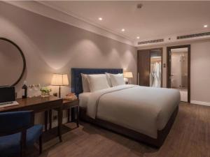 a bedroom with a bed and a desk and a mirror at DN ALT sentafe ppt in Danang
