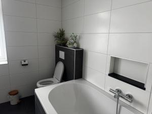 a bathroom with a toilet and a bath tub at Bed en Bike Oudeschild in Oudeschild +36 photos