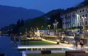 a group of people walking around a city at night at Suite sogni di lago Lecco, Como in Malgrate