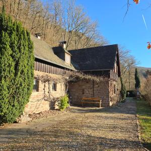 an old stone house with a bench in front of it at Jagdhütte Breidelsley in Nideggen