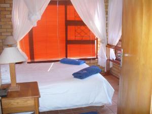 a bedroom with two white beds and a window at Timber and Tide in Cannon Rocks