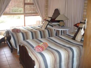 a bedroom with two beds and a window at Timber and Tide in Cannon Rocks