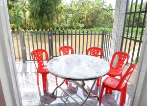 a table and four red chairs on a porch at Mekongdelta in Can Tho