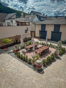 a patio with tables and umbrellas in front of a building at Knabbüüß in Dernau