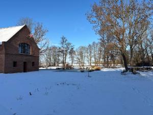 a barn in a snow covered field with trees at Ferienwohnung Domaene Kermen in Kermen
