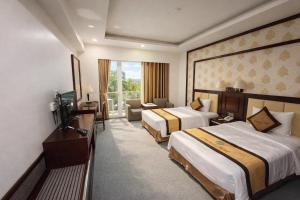 a hotel room with two beds and a television at Central Hotel in Móng Cái