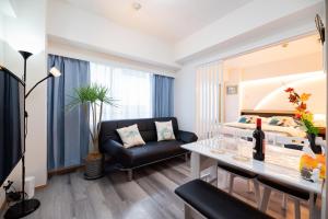 a living room with a couch and a table at Happy Osaka City in Osaka