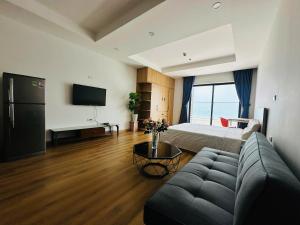 a living room with a couch and a bed at Oceanus Sea View Quy Nhon Apartment in Quy Nhon
