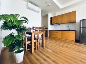 a kitchen and dining room with a table and a plant at Oceanus Sea View Quy Nhon Apartment in Quy Nhon