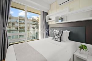a bedroom with a white bed and a large window at Nirasa by Kozystay - Paskal in Bandung +34 photos