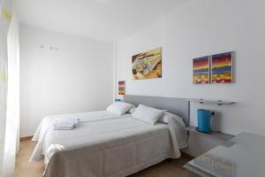 a bedroom with a bed and two paintings on the wall at House Miramar almuñecar in Almuñécar +32 photos