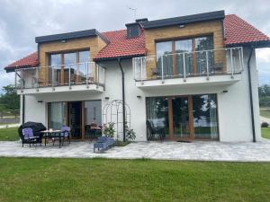 a house with a balcony and a patio at Apartamenty Panoramic-Piecki in Piecki