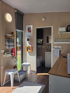 a small kitchen with a refrigerator and a counter top at Fassifern Tiny House 2 by Tiny Away in Lance Field +10 photos