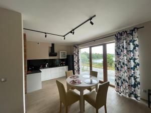 a kitchen and dining room with a table and chairs at Apartamenty Panoramic-Piecki in Piecki