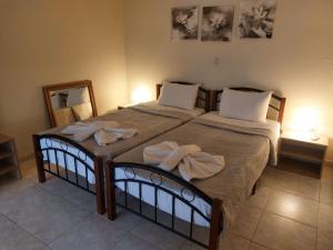 a bedroom with two beds with towels on them at Hellen's Summer house in Keramoti