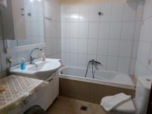 a bathroom with a sink and a bath tub at Hellen's Summer house in Keramoti