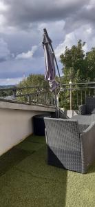 a patio with two chairs and an umbrella at Tsara Home in Le Trait