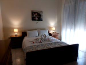 a bedroom with a bed with two swans on it at Hellen's Summer house in Keramoti +11 photos
