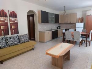 a kitchen with a couch and a table and chairs at Hellen's Summer house in Keramoti