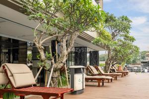 a row of lounge chairs and trees on a building at Nirasa by Kozystay - Paskal in Bandung