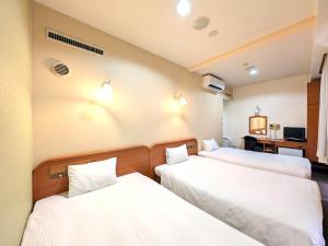 two beds in a hotel room with white sheets at Suizenji Comfort Hotel in Kumamoto +45 photos
