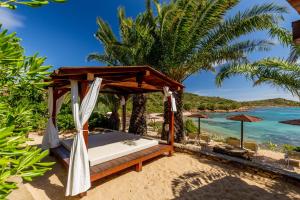 un letto sulla spiaggia con vista sull'oceano di Hotel Don Diego a Porto San Paolo