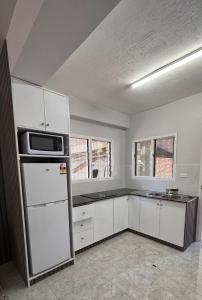 a kitchen with white cabinets and a microwave at 2 bedroom Flat in Namaka,Nadi in Nadi