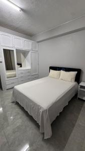 a white bedroom with a large bed and a mirror at 2 bedroom Flat in Namaka,Nadi in Nadi