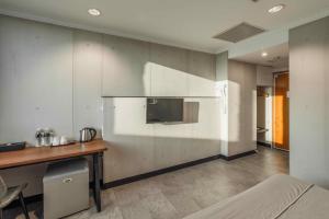 a room with a kitchen with a tv on the wall at Hwa Nan Hotel in Yongkang +27 photos