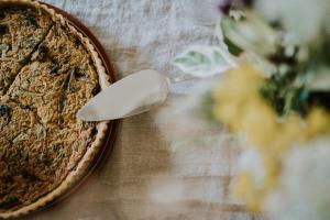 a pie sitting on a wooden table with a spoon at Domaine La Commanderie in Boersch