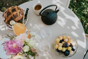 a table with a tea pot and a bowl of fruit at Domaine La Commanderie in Boersch