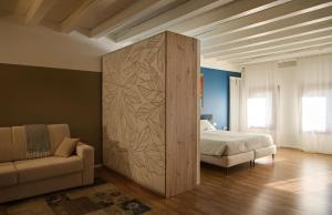 a bedroom with a partition with a bed and a couch at Le Mura Minicase int 3 in Castelfranco Veneto