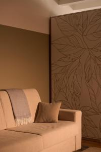 a living room with a couch and a wall with a flower mural at Le Mura Minicase int 3 in Castelfranco Veneto
