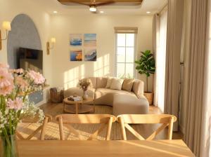 a living room with a couch and a table at Novaworld Phan Thiết - Alala Stay in Bình Sum