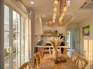 a kitchen and dining room with a table and chairs at Novaworld Phan Thiết - Alala Stay in Bình Sum