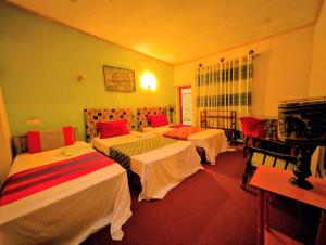 a hotel room with three beds in it at Prasada Resort in Badulla