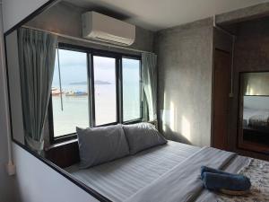 a bedroom with a large bed with a large window at Poohry Seaview in Ko Lanta