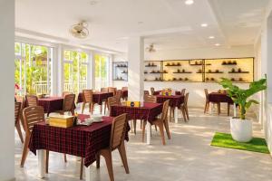a restaurant with tables and chairs in a room at Sân Vườn Hotel Khánh Hòa in Ninh Hòa