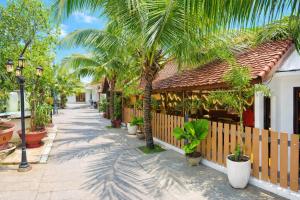 a street with palm trees next to a building at Sân Vườn Hotel Khánh Hòa in Ninh Hòa