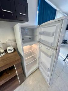 a white refrigerator with its door open in a kitchen at CASA HUELLAS EN LA ARENA in Ixtapa
