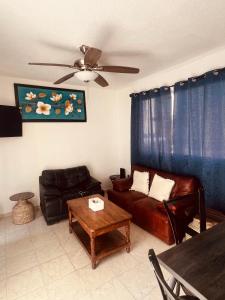 a living room with a couch and a table at CASA HUELLAS EN LA ARENA in Ixtapa