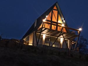 a glass house on top of a hill at night at SUNSET Villa PONIKVA in Kočani