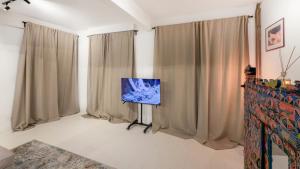a living room with curtains and a flat screen tv at Cosy loft near City Centre, Terra CasaMia in Antwerp