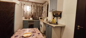 a small kitchen with a sink and a washing machine at Confort Flat in Braşov