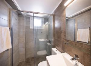 a bathroom with a shower and a toilet and a sink at Santa Marina House in Lefkada